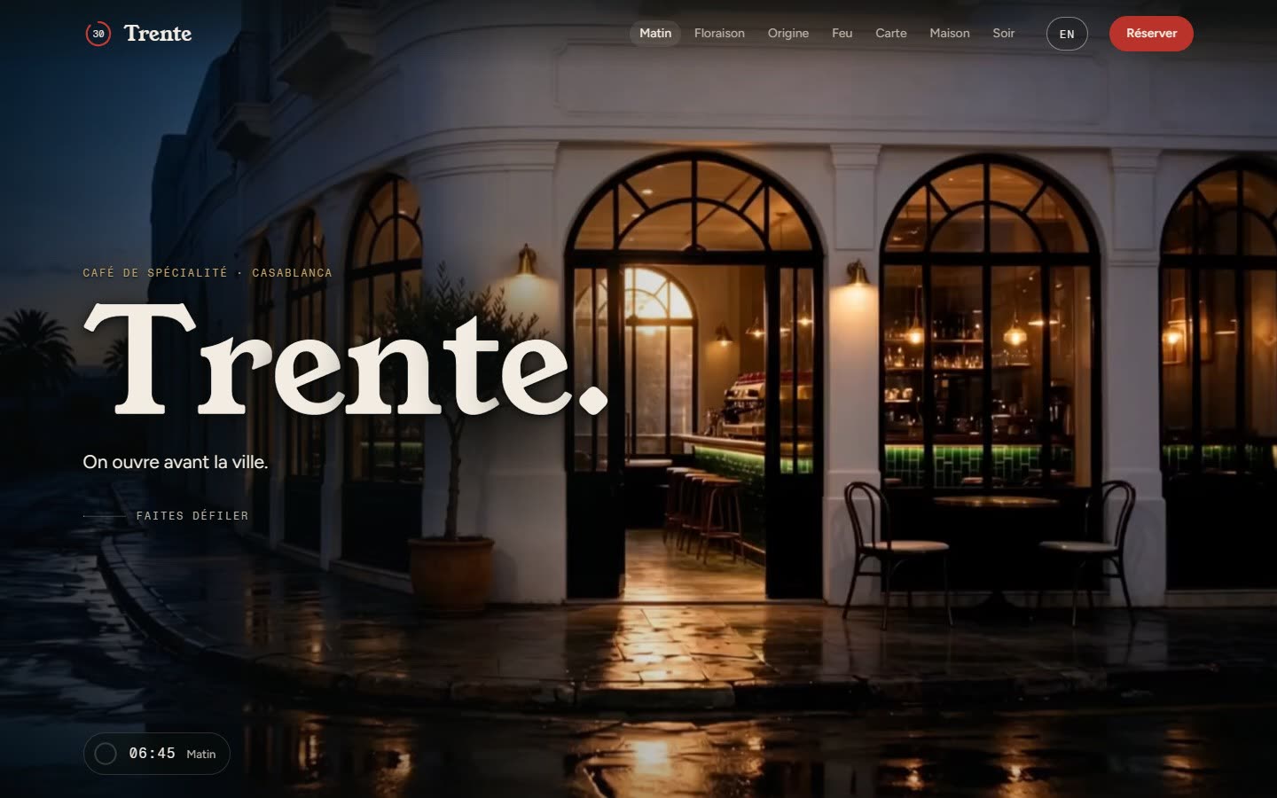 Le site Café Trente : la façade blanche du café, la nuit, sous la pluie